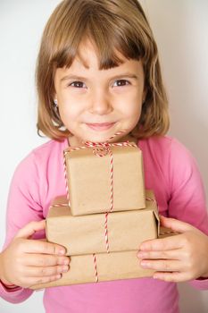 Child holds a Christmas decor and gifts on a white background. Selective focus. Happy.