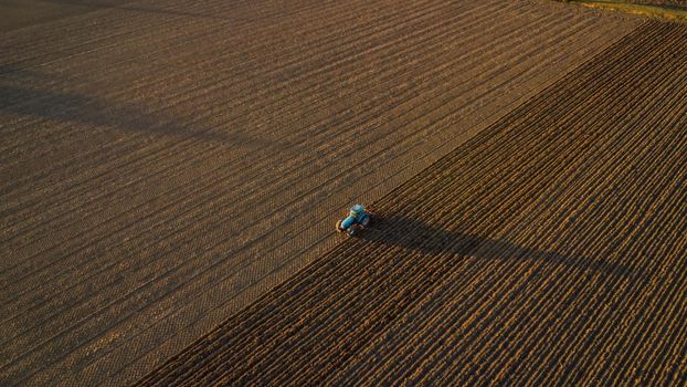 farmer with tractor leveling land in the countryside.