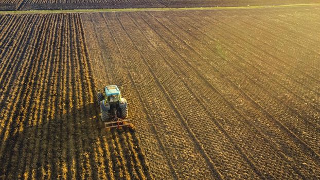 farmer with tractor leveling land in the countryside.