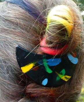 Small Black, red, yellow hair extension combined with a black hair clip