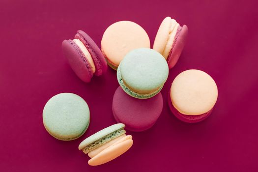 Pastry, bakery and branding concept - French macaroons on cherry pink background, parisian chic cafe dessert, sweet food and cake macaron for luxury confectionery brand, holiday backdrop design