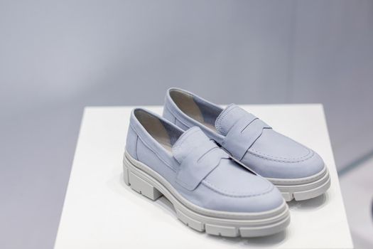 Light blue beautiful fashionable female loafers shoes. Studio shoot on white background for magazine, website in Internet or catalog.