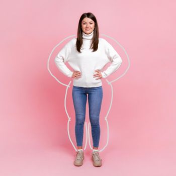 Body care, slimming and workout. Full length portrait of woman drown around, enjoying result of weight loss, standing with hands on hips. Indoor studio shot isolated on pink background.