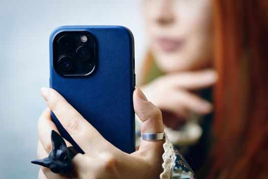 Woman blogger takes selfie on iPhone 13 pro. Female's hand with gothic ring holding smartphone. Gadget with triple-lens camera. Bishkek, Kyrgyzstan - January 24, 2022