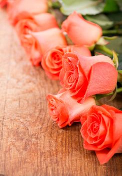 bouquet of rose with green leaves on a wooden