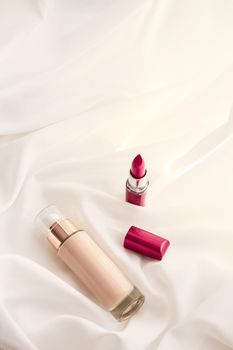 Cosmetic branding, glamour and skincare concept - Beige tonal cream bottle make-up fluid foundation base and red lipstick on silk background, cosmetics products as luxury beauty brand holiday design