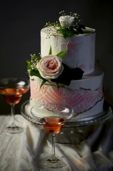 wedding bunk cake decorated with fresh flowers on a dark background