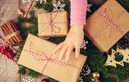 Child holds a Christmas decor and gifts on a white background. Selective focus. Happy.