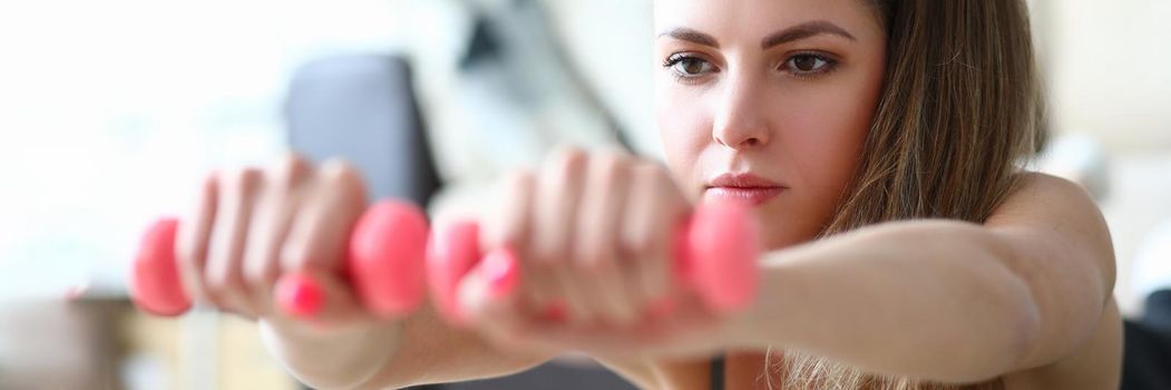 Portrait of young lying woman with dumbbells. Fitness and sport concept