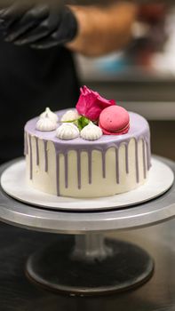 chef usign macaron , flowers and text sign for a celebration cake