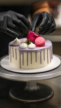 chef usign macaron , flowers and text sign for a celebration cake