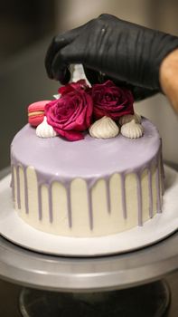 chef usign macaron , flowers and text sign for a celebration cake