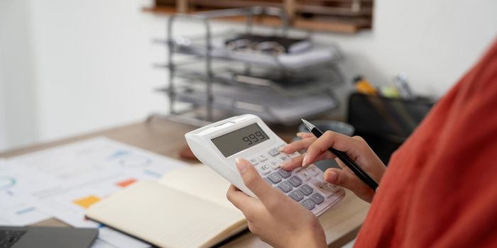 Close up hands businessman doing finances with using calculator for debt or tax