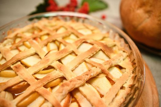 Close-up homemade classic American pumpkin pie, with sliced caramelized apples and flaky crust lattice for Thanksgiving dinner. Autumn holidays. Halloween and Thanksgiving Day. Still life with food