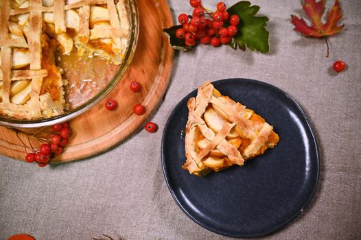 Flat lay. Still life with a slice of freshly baked homemade pumpkin apple pie, with a crispy crust on a blue navy ceramic plate. Thanksgiving Day. Halloween. Autumn festival. Festive baking concept