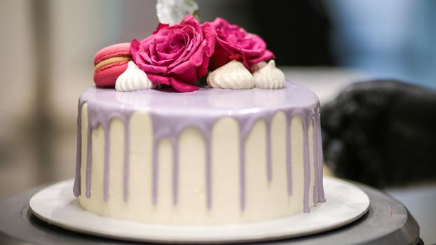 chef usign macaron , flowers and text sign for a celebration cake