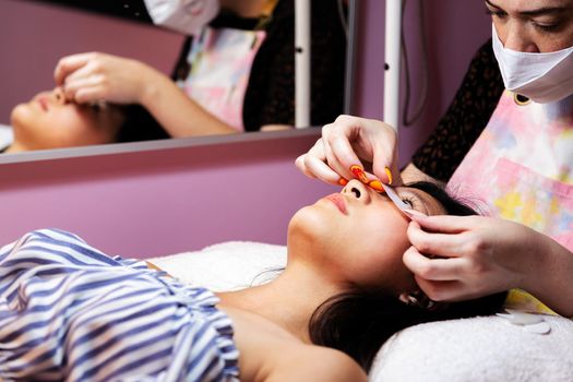 young woman relaxing in the beauty salon while being prepared to have her eyelash extensions done, concept of beauty and wellness
