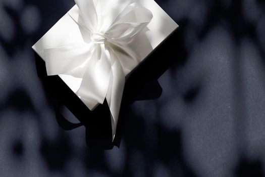 Anniversary celebration, shop sale promotion and luxe surprise concept - Luxury holiday white gift box with silk ribbon and bow on black background, luxe wedding or birthday present