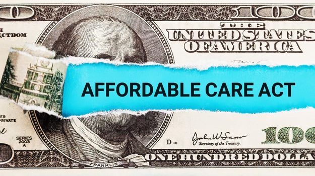 Words Affordable Care Act ACA written on with American Dollar-bills. The word Affordable Care Act on dollar usa background. The Patient Protection and Affordable Care Act.