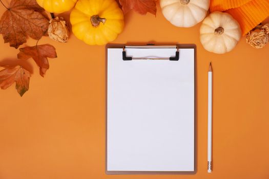 Blank tablet for text next to pumpkins and autumn leaves. Autumn theme mockup.