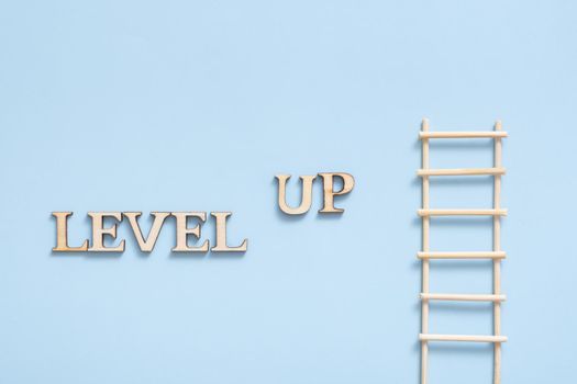 Level up wooden inscription on a colored background with grain. Achievement concept. High quality photo