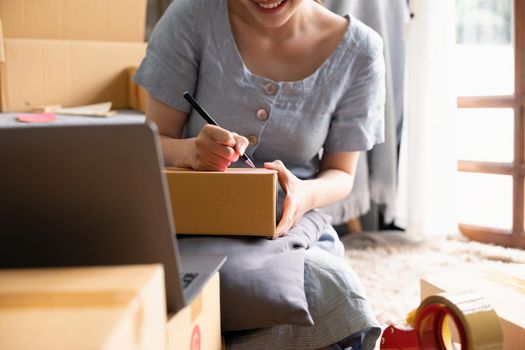 Small businesses SME owners female entrepreneurs writing address on receipt box and check online orders to prepare to pack the boxes, sell to customers, sme business ideas online
