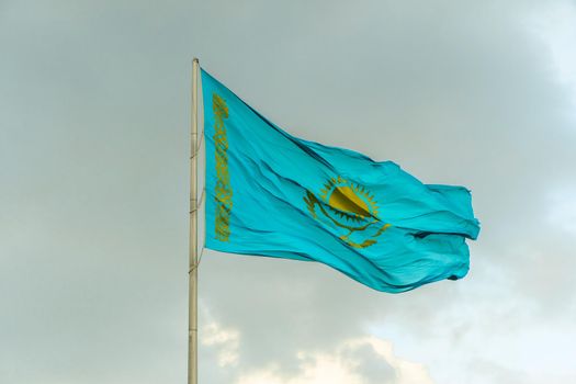 Flag of Kazakhstan on sky background. Waving flag of Republic of Kazakhstan. Fabric textures flowing flag of Kazakhstan.