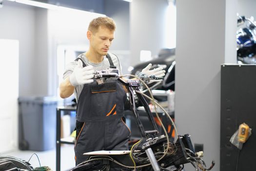 A man repairs the steering wheel of a motorcycle. Motorcycle club service center, bike repair in the garage