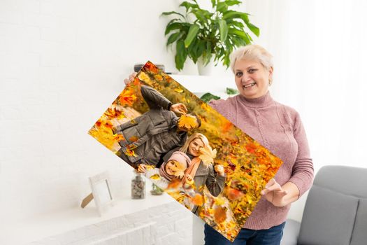 woman holding a photo of autumn, canvas.
