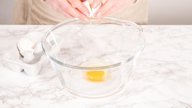 Step by step. Mixing ingredients in a glass mixing bowl to bake a chocolate cupcake.
