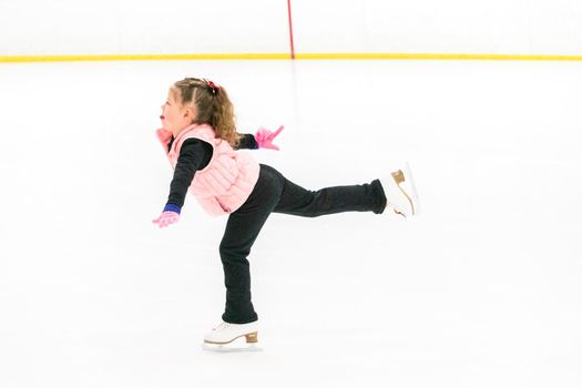 Little skater practicing her elements at the morning figure skating practice.
