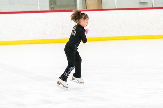 Little skater practicing her elements at the morning figure skating practice.