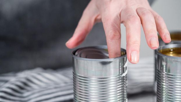 Openning canned white beans with can opener.