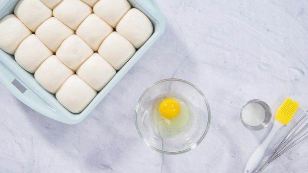 Flat lay. Preparing dinner rolls from the frozen dough in baking pan.