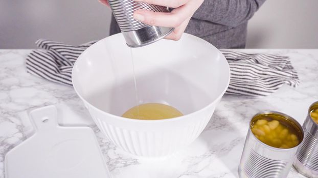 Openning canned white beans with can opener.