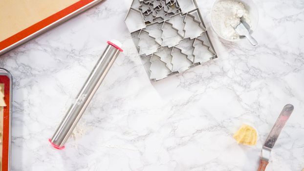 Flat lay. Rolling out sugar cookie dough to bake Christmas cookies.