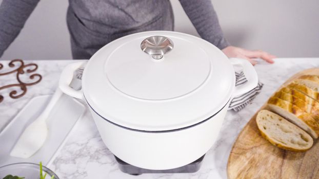 Cooking vegetarian white bean soup in cast iron dutch oven.