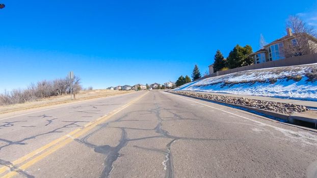 Driving on typical paved roads in a suburban upscale residential neighborhood of America.
