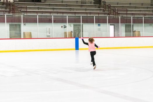 Little skater practicing her elements at the morning figure skating practice.