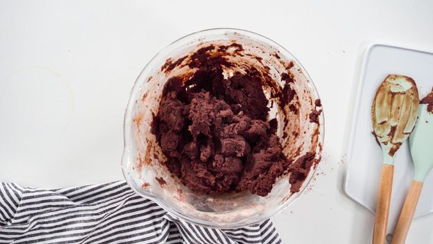Step by step. Flat lay. Mixing ingredients in a glass mixing bowl to bake chocolate cookies.