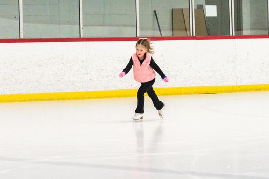 Little skater practicing her elements at the morning figure skating practice.