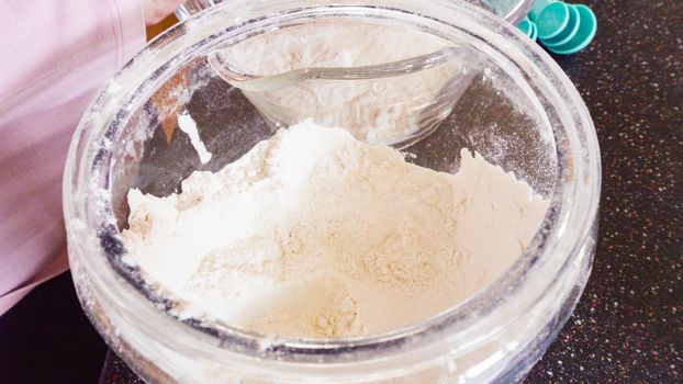 Mixing ingredients in a glass mixing bowl to make homemade pancakes.