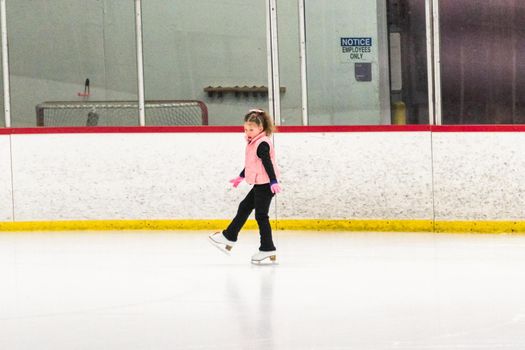 Little skater practicing her elements at the morning figure skating practice.