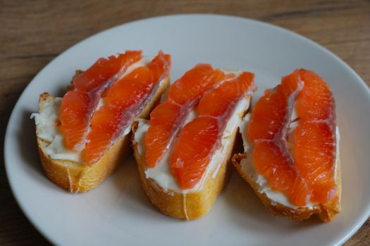 Salmon sandwiches on a white plate. Background of food and snacks