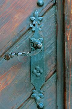 Old iron doorknob in a wooden door