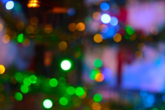 Blurred background. Bright lights of the Christmas tree