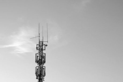 Black and white photo. Cell tower against the sky. Modern technologies