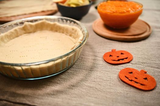 Fresh raw ingredients for making traditional pumpkin classic pie with crispy crust. Copy advertising space. Thanksgiving Day. Halloween. Autumn holidays. Still life with food. Baking concept