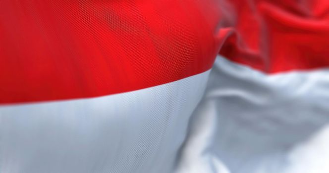 Close-up view of the Indonesia national flag waving in the wind. The Republic of Indonesia is a State of Southeast Asia. Fabric textured background. Selective focus