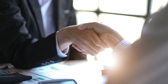 Close up of Business people shaking hands, finishing up meeting, business etiquette, congratulation, merger and acquisition concept.